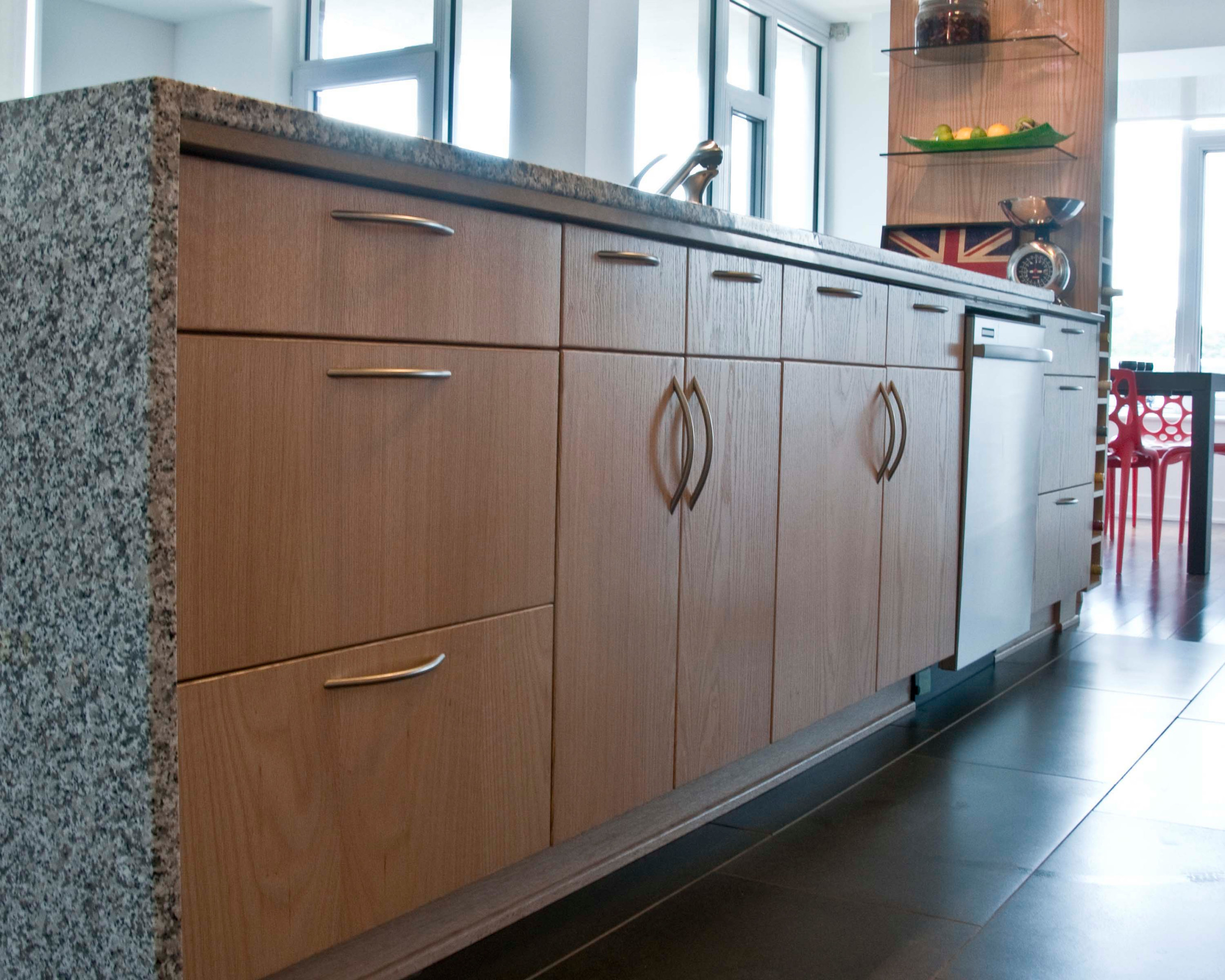A kitchen island with varying sizes of door pulls