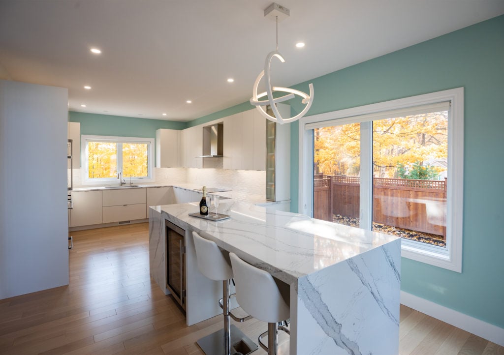 A kitchen design with a coastal theme and a waterfall island countertop.