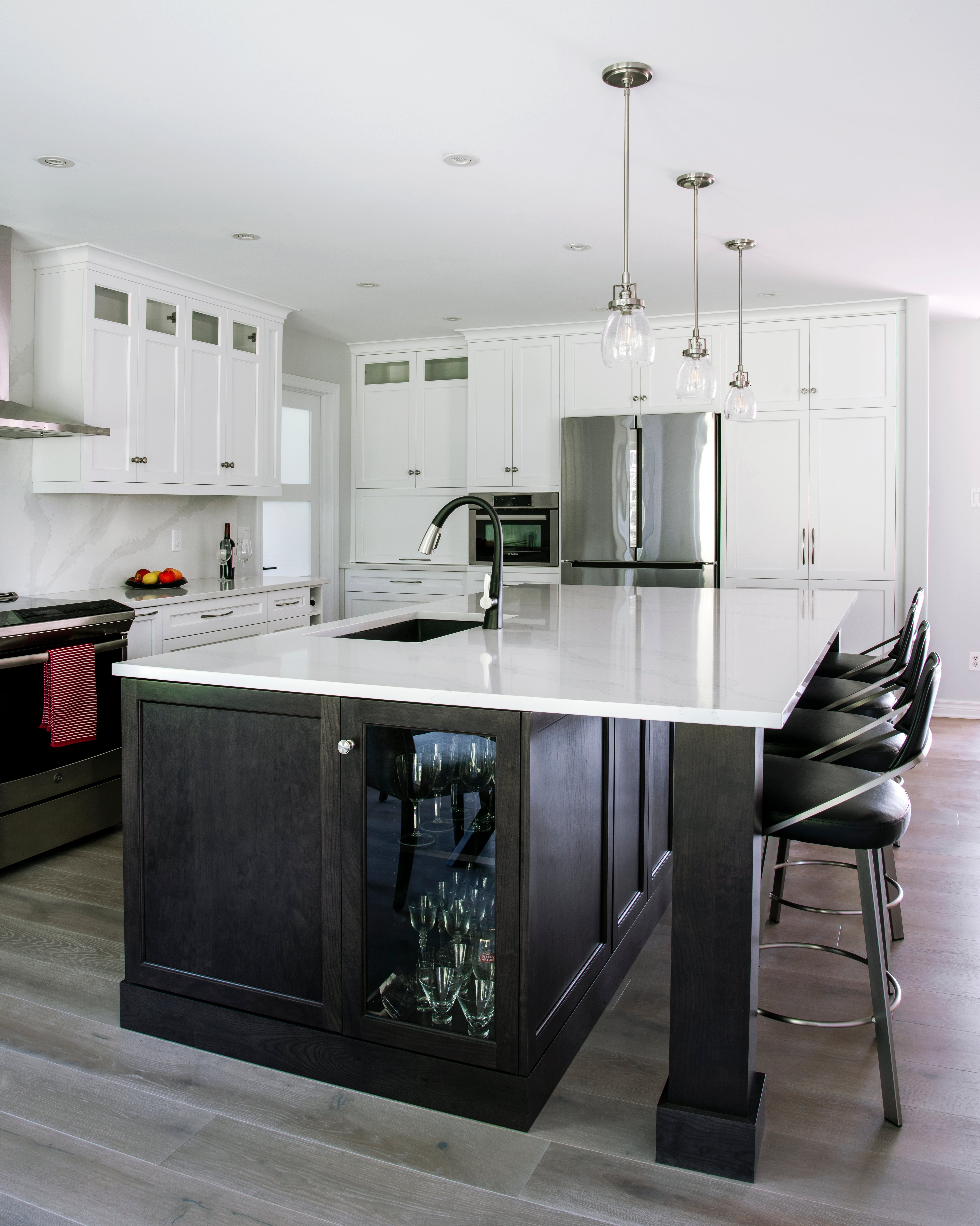 A white kitchen with a dark cherry island in the centre.