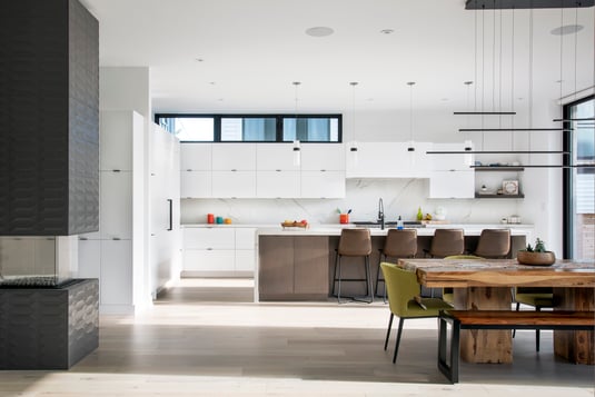 A spacious, white-themed kitchen area with natural light.