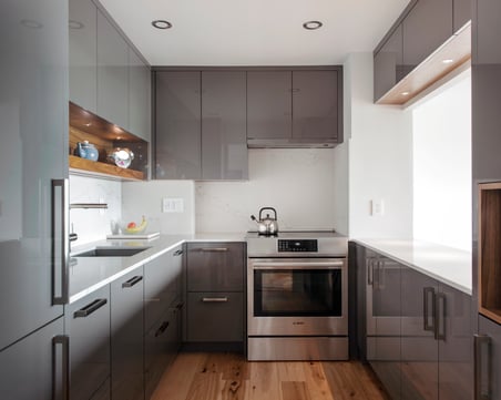 A high-gloss custom cabinetry system with a gray colour scheme.