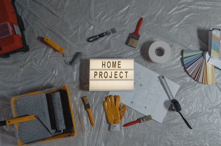 A collection of painting tools and a sign that says "Home Project".