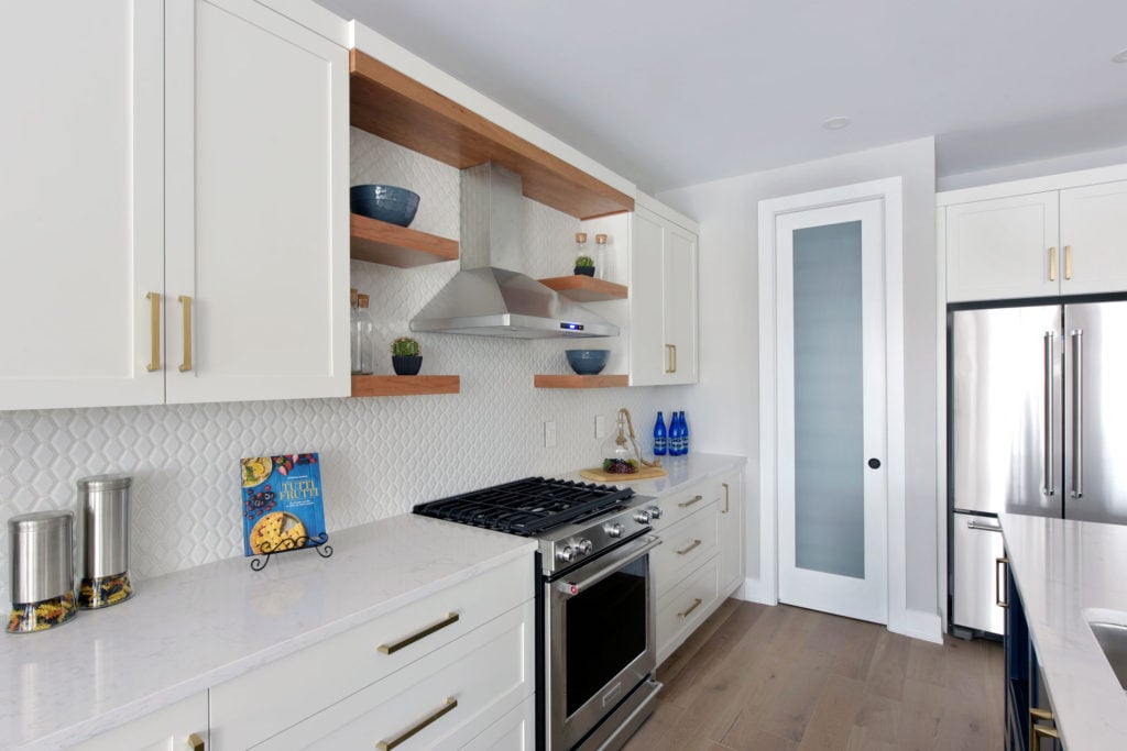 A gas stove and hood range in a custom kitchen design