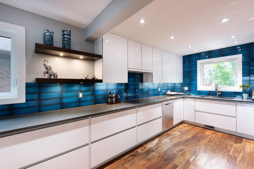 A modern Deslaurier kitchen with a bright blue backsplash.