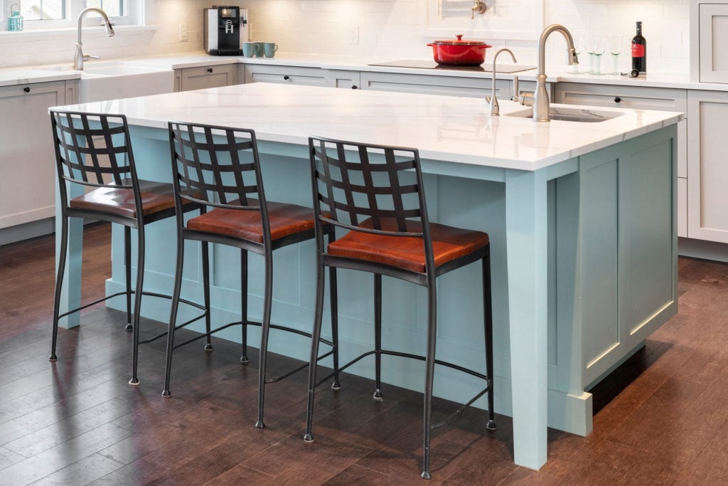 A kitchen island with a deep counter depth and tucked in bar stools.