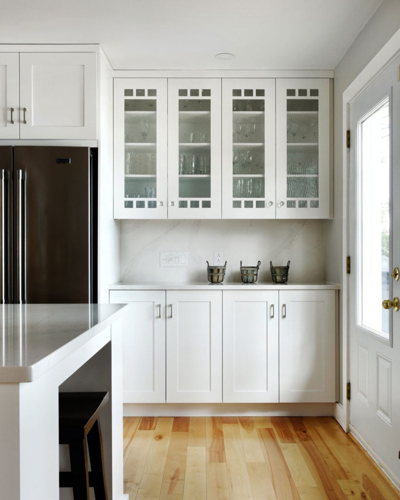 Glass cabinetry next to an open window.