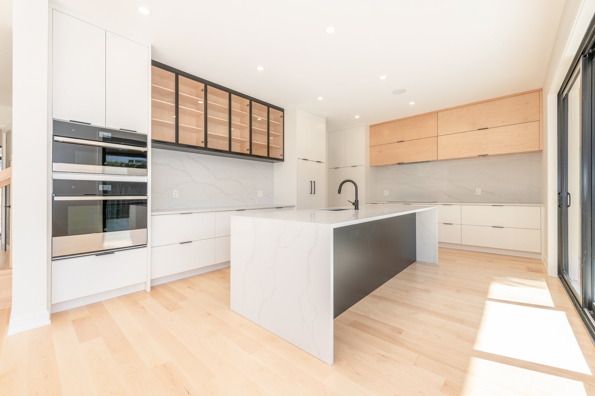A brand-new kitchen by Deslaurier with empty shelving.