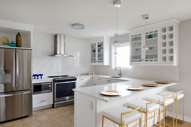 A full-height backsplash tastefully adorns a newly renovated kitchen.