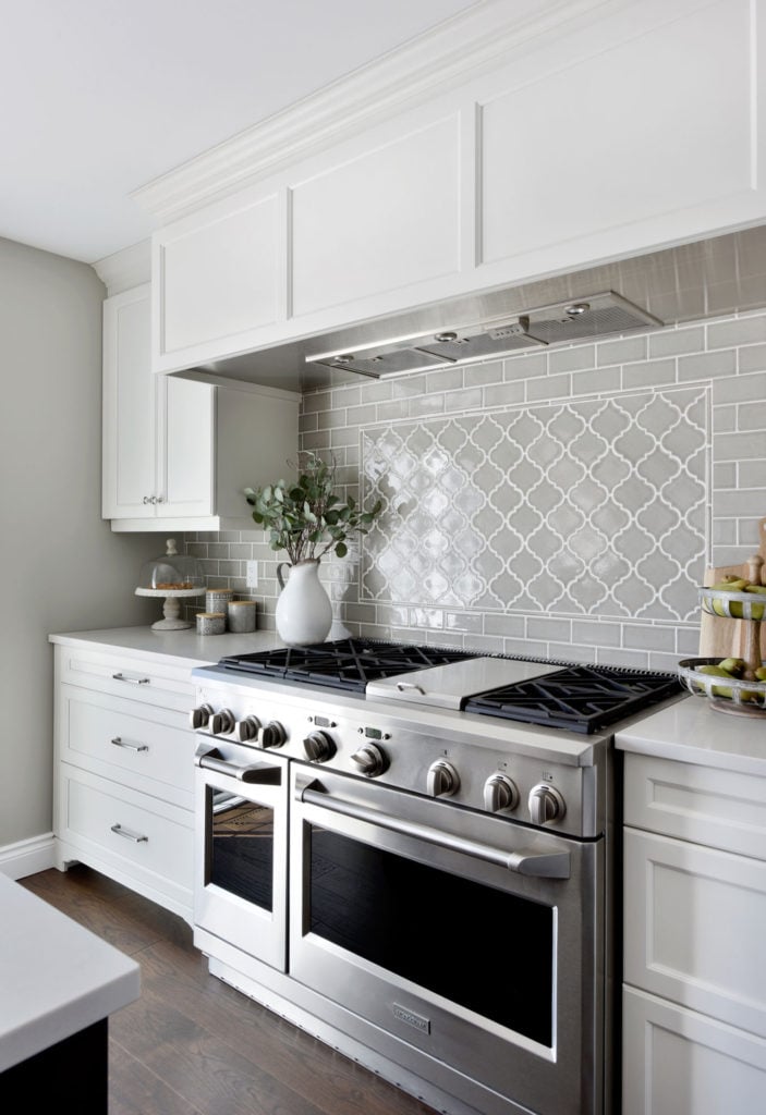 A gas range and a chic tiled backsplash.