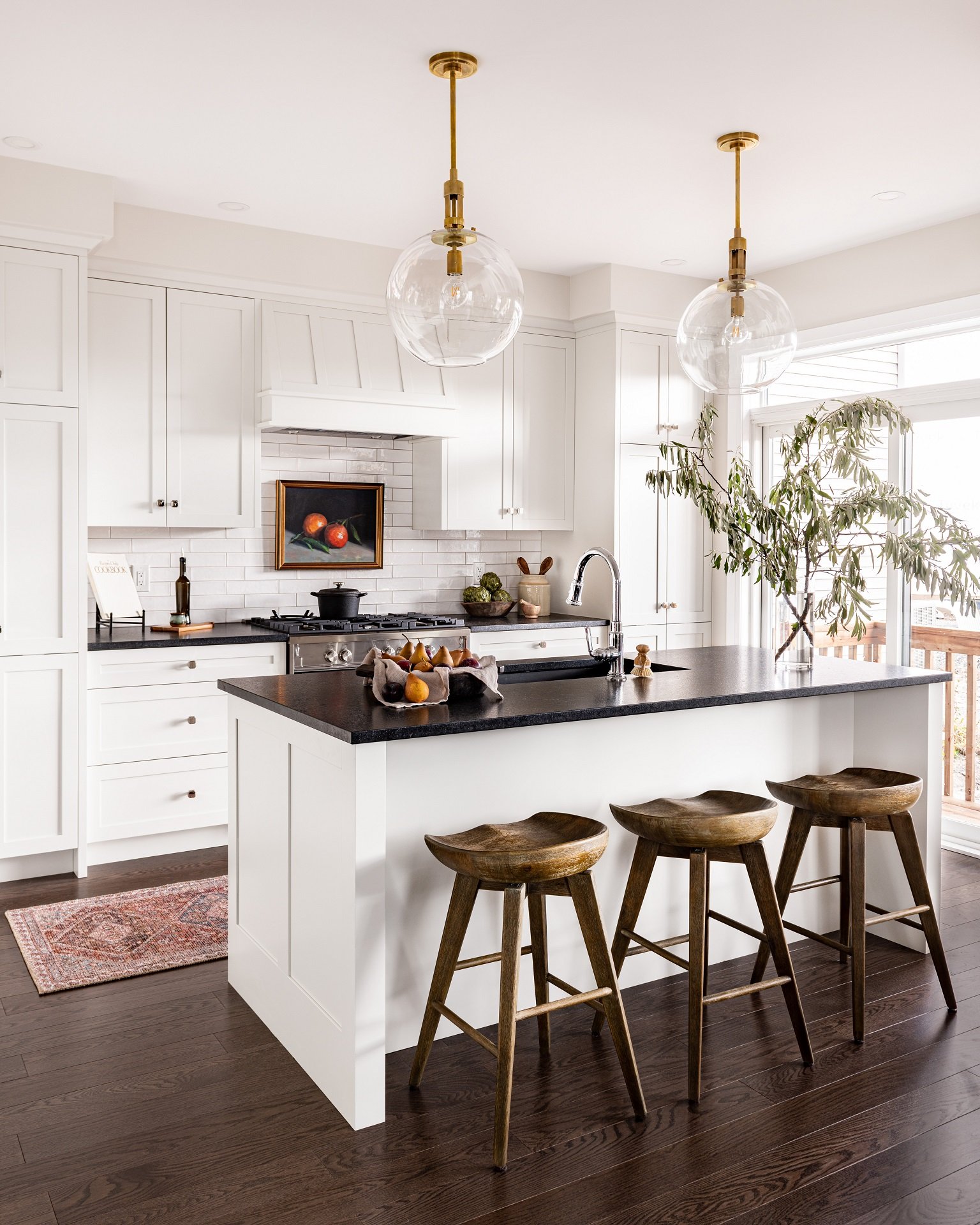 A dark black countertop provides stunning contrast to white cabinets.