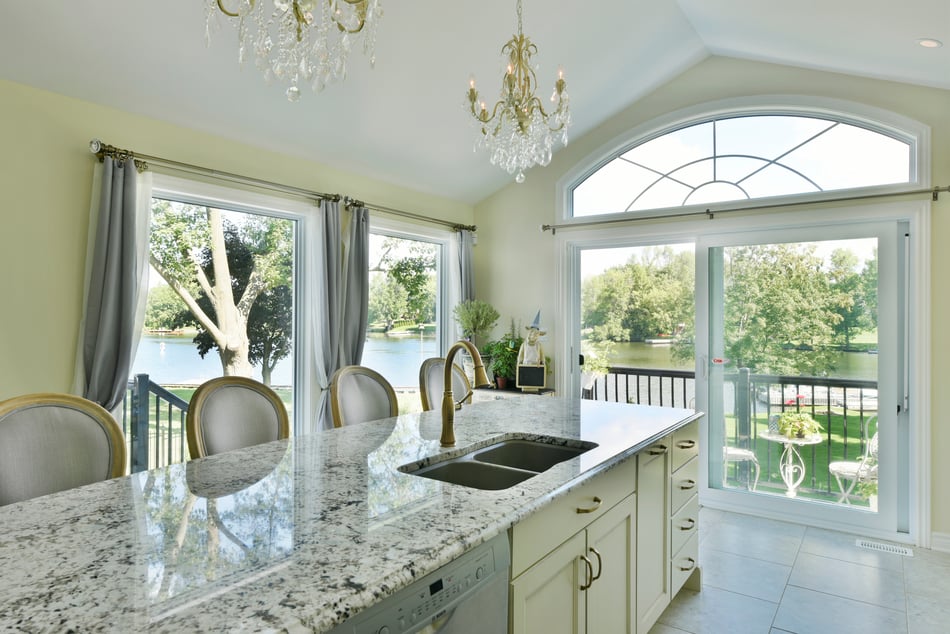 A speckled granite countertop on a kitchen island in a traditional kitchen design.