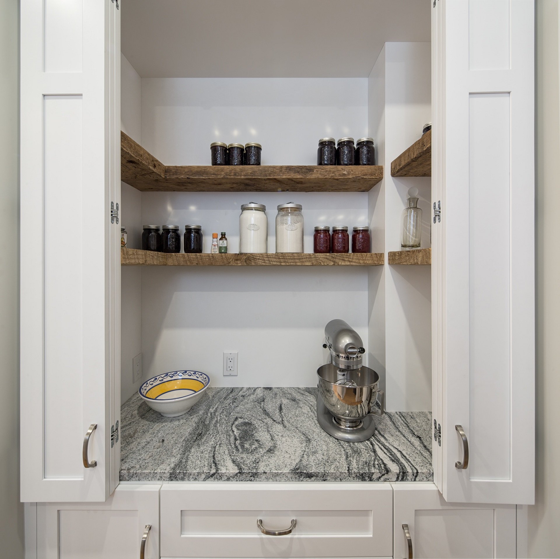 A pantry with wooden floating shelves.